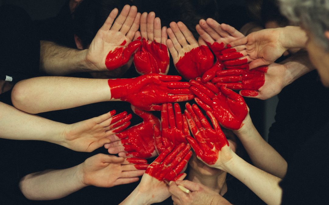 hands with red paint making a heart